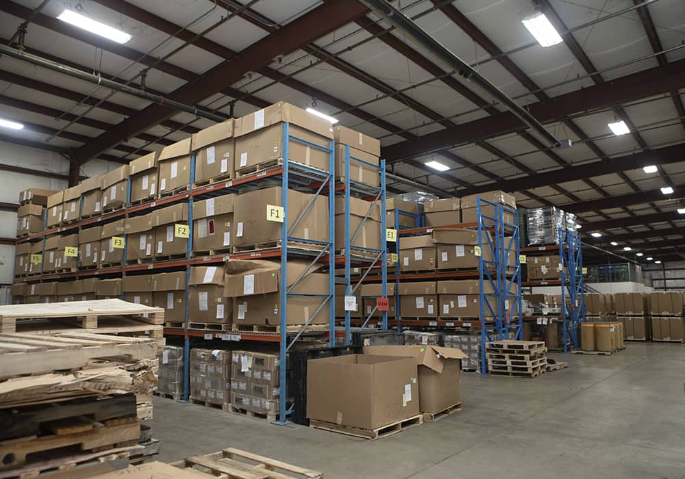 A TAC Industries logistics and kitting warehouse filled with cardboard boxes.