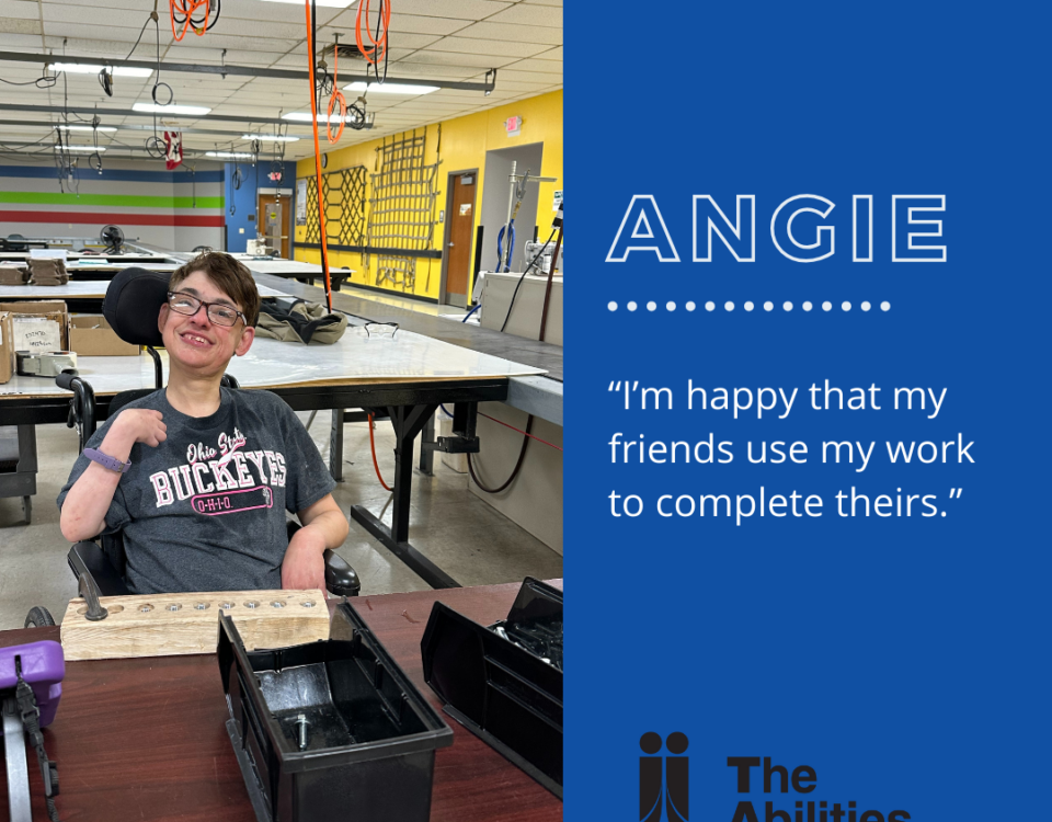 Support In The Workplace: Angie smiling at a table, sharing that she is happy that her friends use her work to complete theirs.