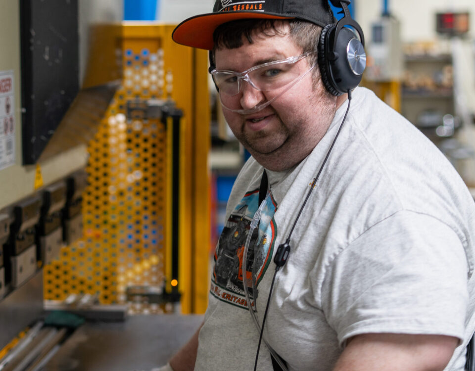 A person wearing safety gear operates machinery. Celebrating TAC Industries team.