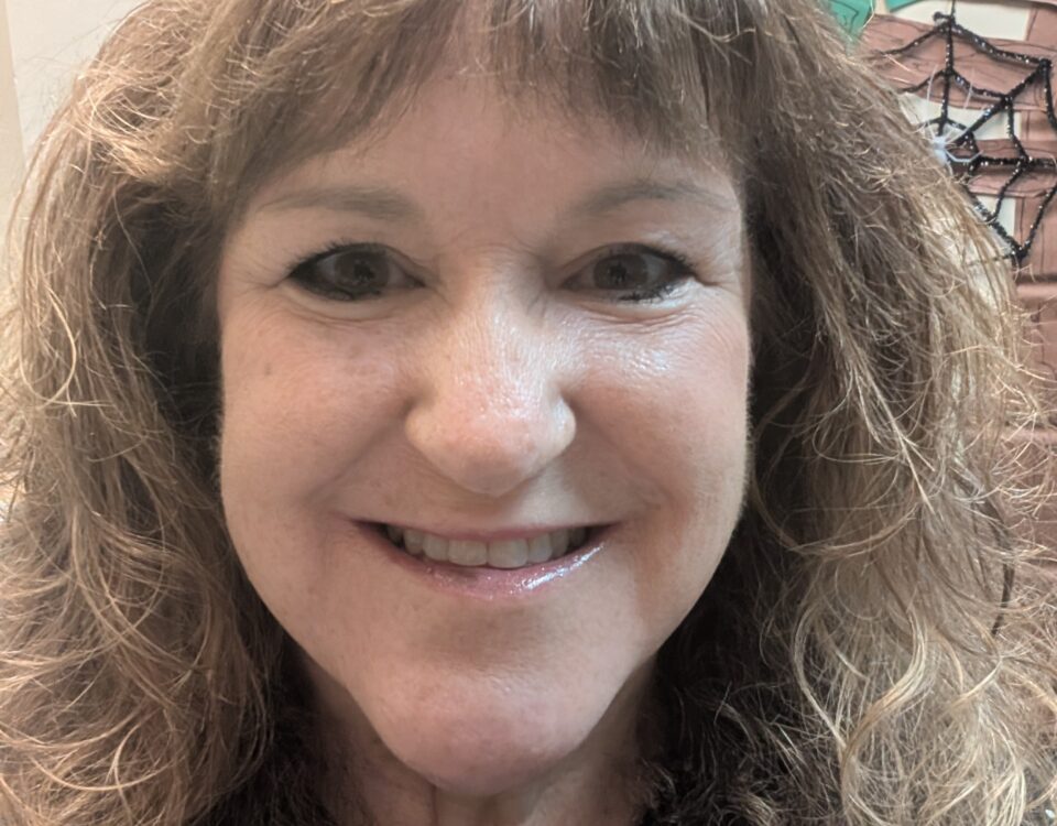 A smiling individual with curly hair.